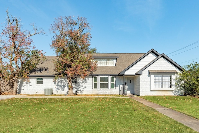 view of front of home with cooling unit and a front yard