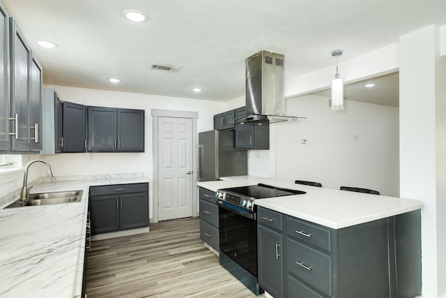 kitchen with pendant lighting, sink, electric range, stainless steel fridge, and extractor fan