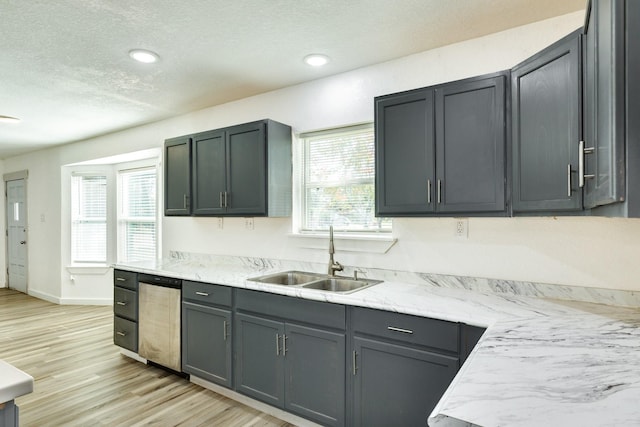 kitchen with sink, stainless steel dishwasher, gray cabinets, light wood-type flooring, and a textured ceiling