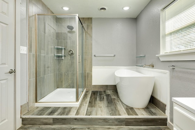 bathroom with hardwood / wood-style flooring and plus walk in shower