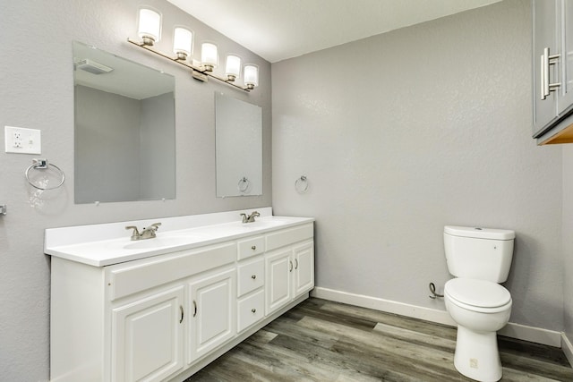 bathroom featuring vanity, hardwood / wood-style flooring, and toilet