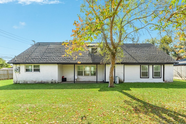 rear view of house featuring a lawn