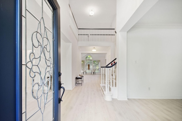 entryway with light wood-type flooring and a high ceiling