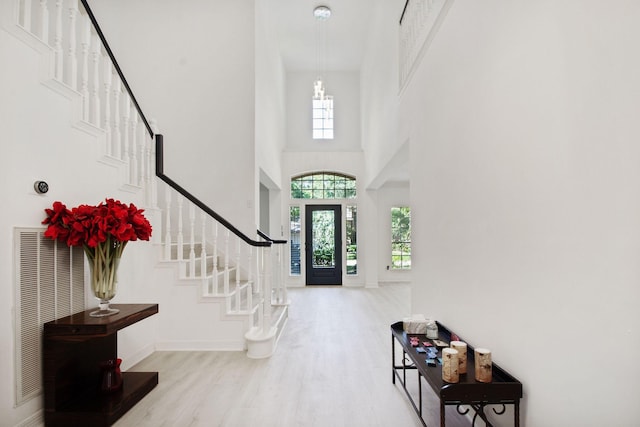 foyer entrance with light hardwood / wood-style floors and a high ceiling