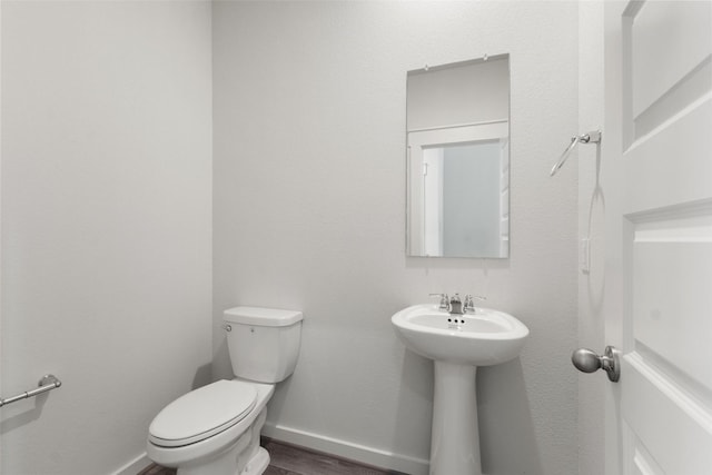 4303 Maple Root Ln, Pinehurst, TX 77362 - bathroom with toilet, baseboards, wood finished floors, and a sink