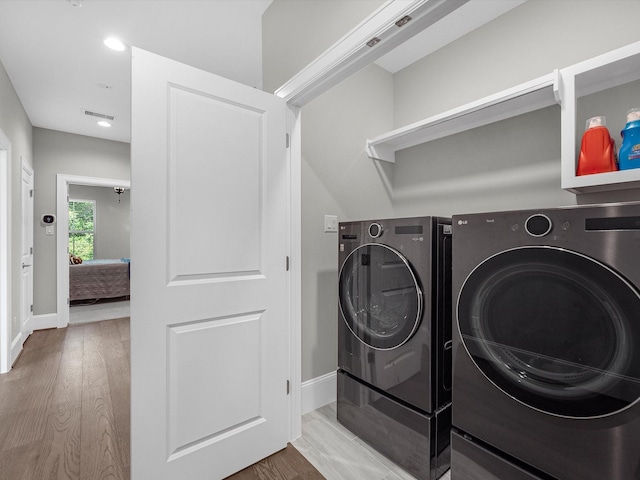 laundry room featuring washer and clothes dryer and hardwood / wood-style flooring