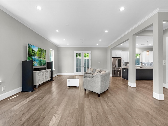 living room featuring french doors, light hardwood / wood-style flooring, and ornamental molding