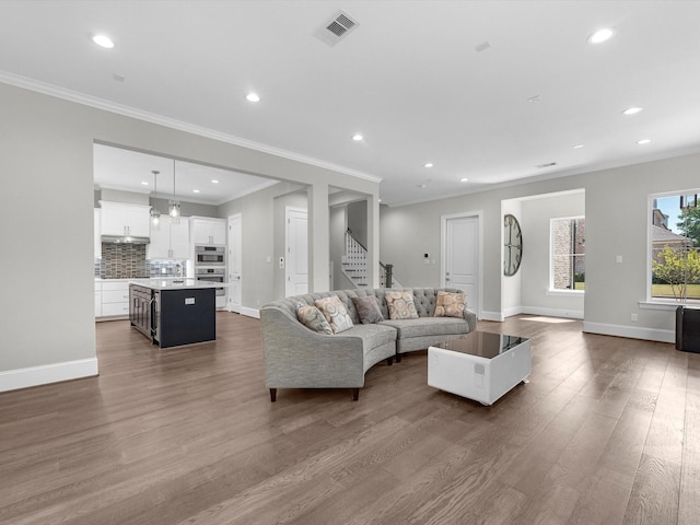 living room with crown molding and hardwood / wood-style flooring