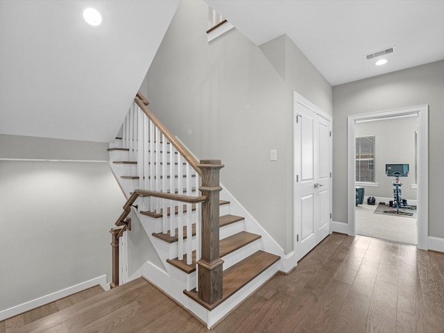 staircase with hardwood / wood-style flooring