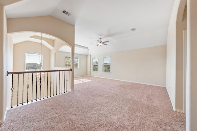 carpeted spare room featuring ceiling fan and vaulted ceiling