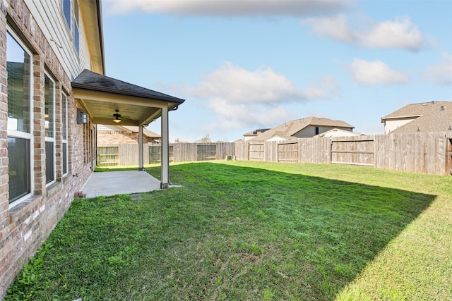 view of yard with ceiling fan and a patio