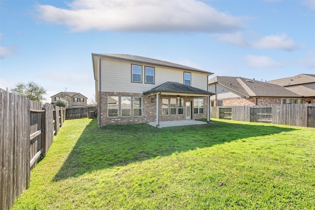 rear view of house featuring a lawn and a patio