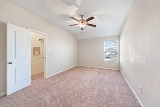 spare room with ceiling fan, light colored carpet, and lofted ceiling