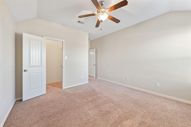 unfurnished bedroom with ceiling fan, light colored carpet, lofted ceiling, and a spacious closet