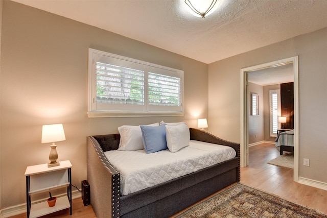 bedroom featuring hardwood / wood-style floors and a textured ceiling