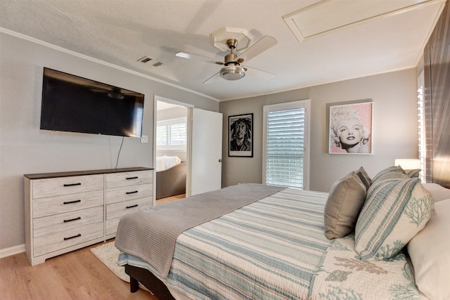 bedroom with ceiling fan, crown molding, and light wood-type flooring