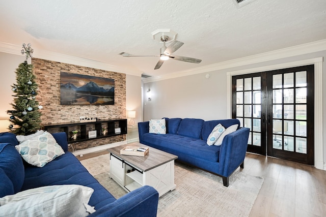 living room featuring french doors, crown molding, ceiling fan, a textured ceiling, and light hardwood / wood-style floors