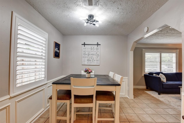 dining space with light tile patterned floors and a textured ceiling