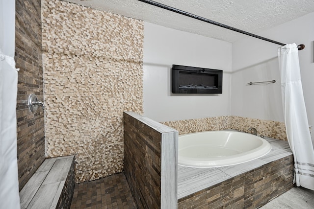 bathroom featuring separate shower and tub and a textured ceiling