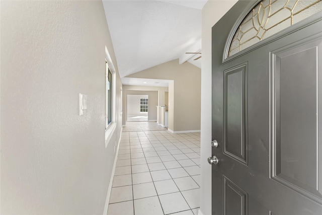 foyer entrance with vaulted ceiling with beams, ceiling fan, and light tile patterned flooring