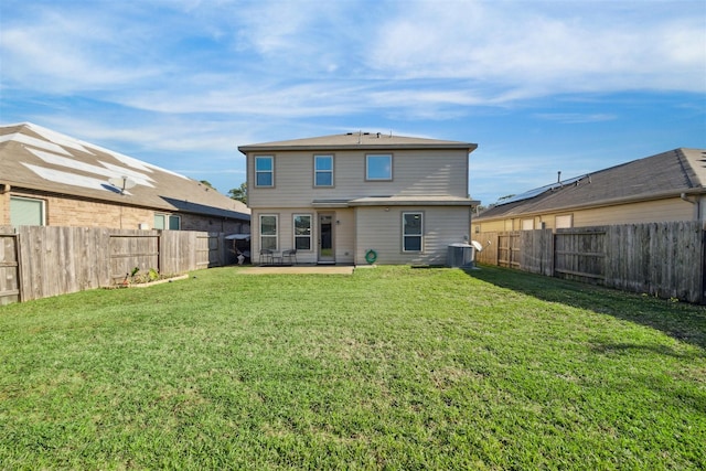 back of property featuring central air condition unit and a lawn