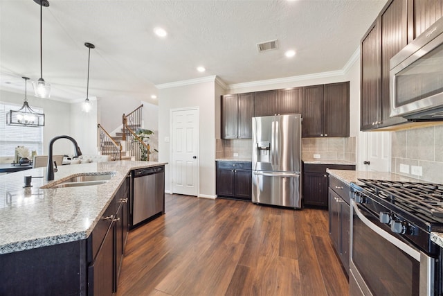 kitchen with sink, decorative light fixtures, dark brown cabinets, and appliances with stainless steel finishes