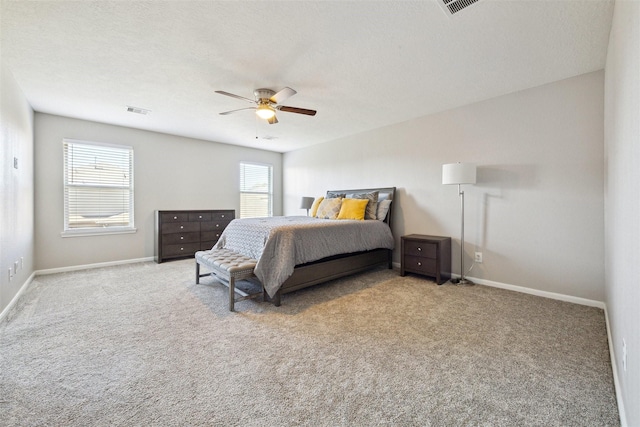 bedroom featuring light carpet, a textured ceiling, and ceiling fan