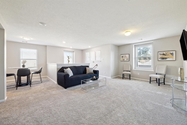 carpeted living room featuring a textured ceiling