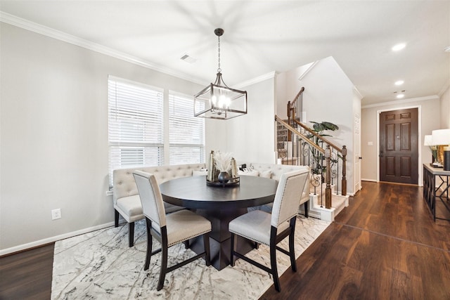 dining area with dark hardwood / wood-style flooring, ornamental molding, and a chandelier