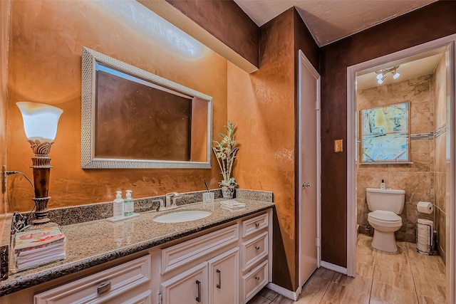 bathroom with tile patterned flooring, vanity, and toilet