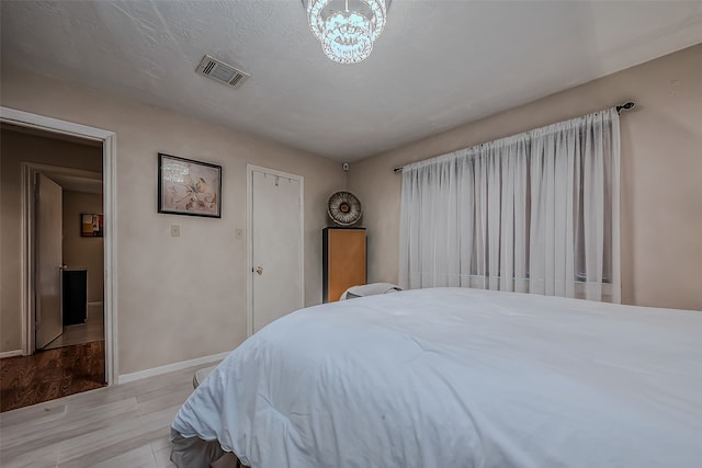 bedroom with a textured ceiling and an inviting chandelier