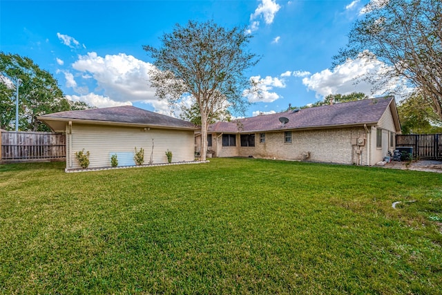 rear view of property with a yard