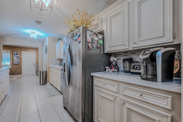 kitchen featuring decorative backsplash, light tile patterned flooring, white cabinetry, and stainless steel refrigerator with ice dispenser