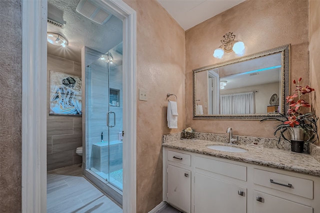 bathroom with vanity, toilet, and a shower with door