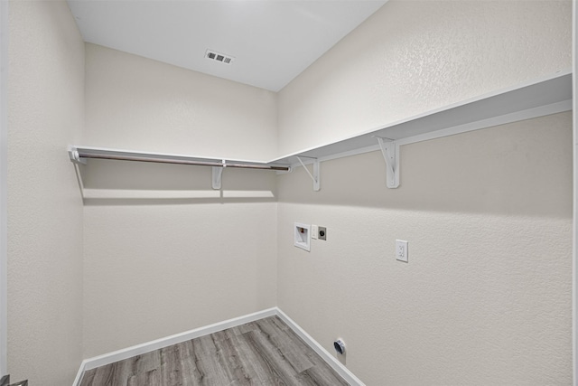 clothes washing area featuring washer hookup, electric dryer hookup, and hardwood / wood-style flooring