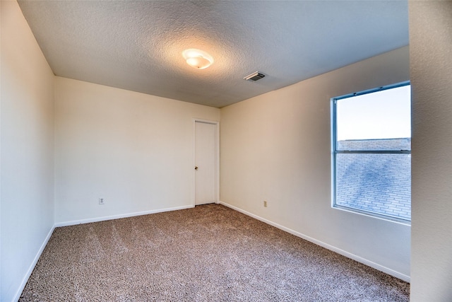 unfurnished room with carpet flooring and a textured ceiling