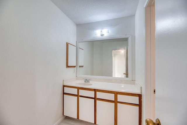 bathroom with tile patterned flooring, vanity, and a textured ceiling