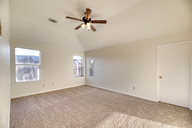 carpeted spare room featuring vaulted ceiling and ceiling fan