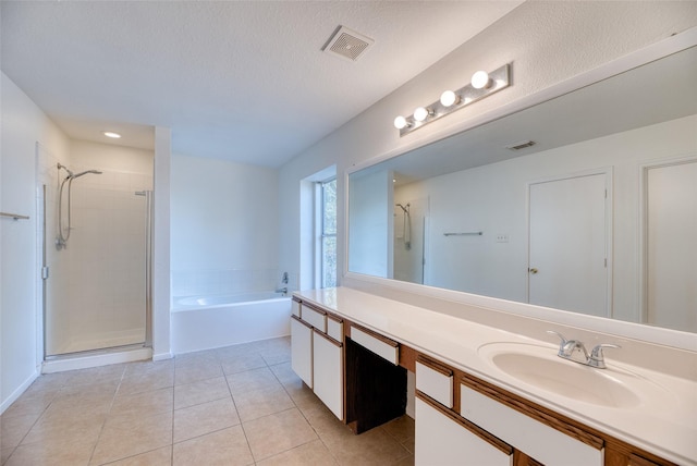 bathroom with tile patterned flooring, vanity, a textured ceiling, and independent shower and bath