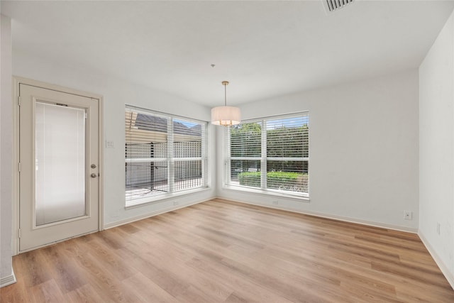 unfurnished dining area featuring light wood-type flooring