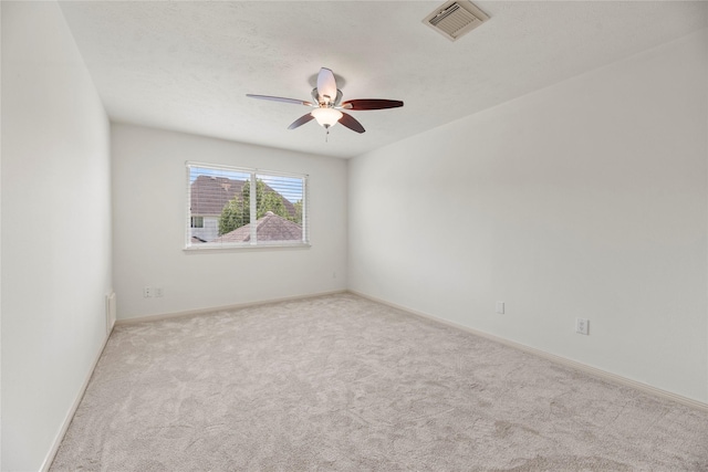 spare room featuring light colored carpet and ceiling fan