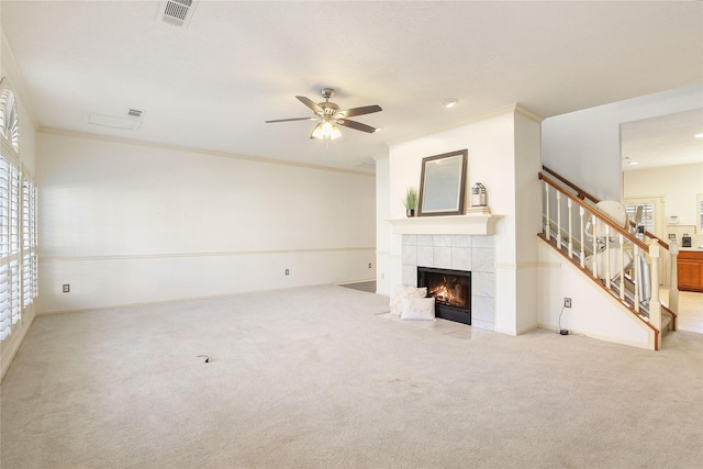 unfurnished living room with a fireplace, light colored carpet, ceiling fan, and ornamental molding