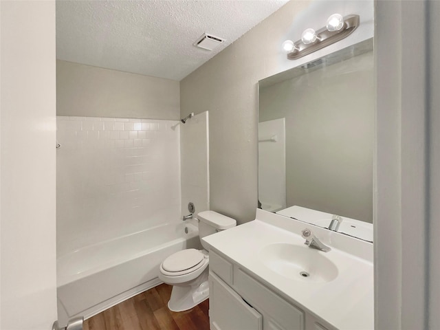 full bathroom with vanity, wood-type flooring, toilet, a textured ceiling, and shower / bath combination