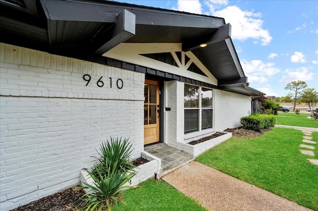 view of exterior entry with a lawn