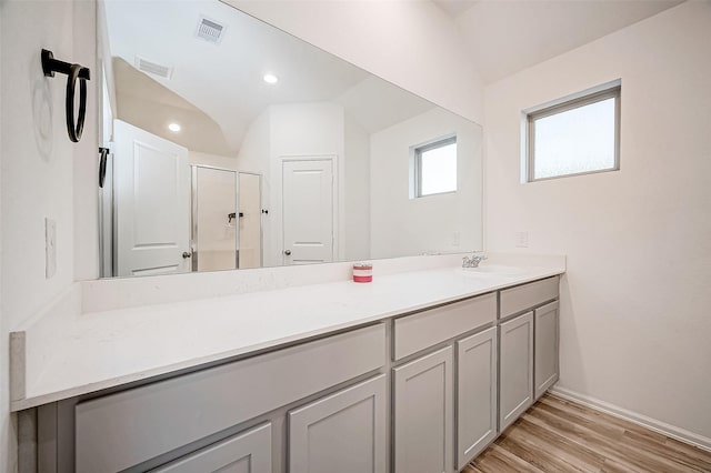 bathroom featuring a shower with door, vanity, wood-type flooring, and lofted ceiling