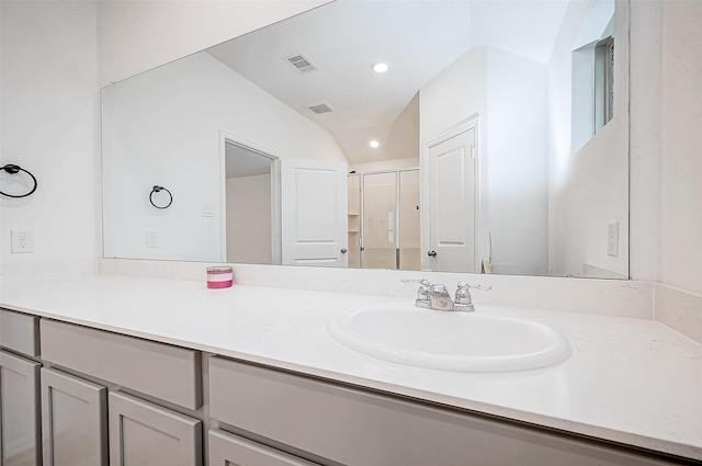 bathroom featuring vanity, lofted ceiling, and walk in shower