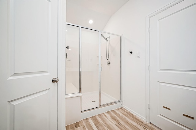 bathroom featuring a shower with door and wood-type flooring