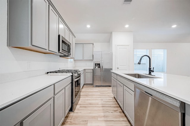 kitchen featuring gray cabinets, sink, light hardwood / wood-style flooring, and appliances with stainless steel finishes