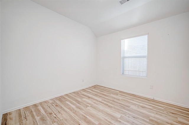 unfurnished room featuring vaulted ceiling and light wood-type flooring