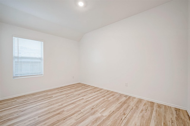 unfurnished room featuring light hardwood / wood-style floors and lofted ceiling